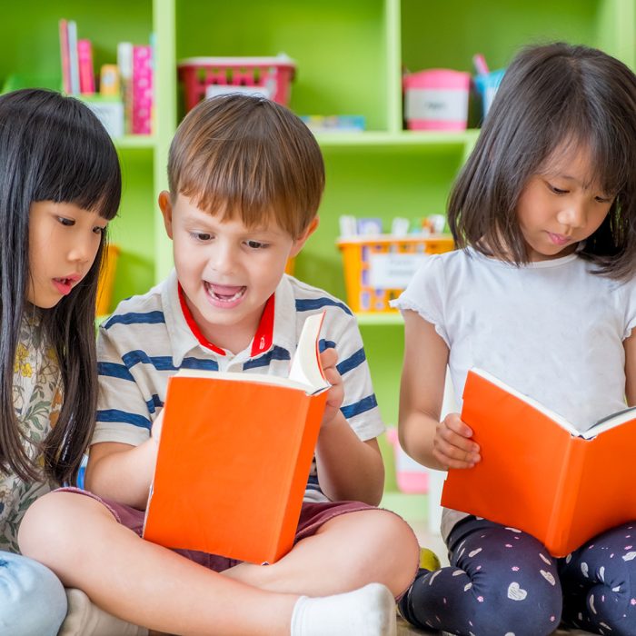 Children sitting on floor and reading tale book  in preschool library,Kindergarten school education concept